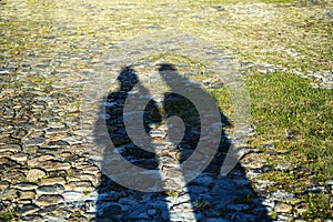 Top view of shadows of two people in strong sun