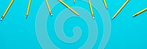 Top view of sharpened pencils over turquoise blue background with copy space