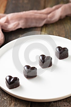 Top view shot of blackheart shaped cholates on the white plate