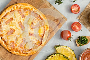 Top view shot of delicious tasty juicy of Hawaiian traditional Italian crust thin crispy ham and pineapple pizza placed on wooden