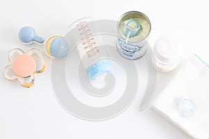 Top view shot of feeding bottles, baby food, baby rattle, pacifier and disposable towels