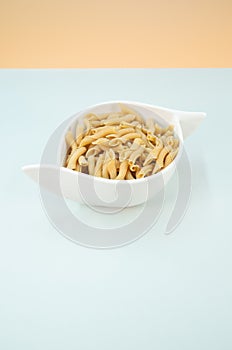 Top view shot of italian pasta in a canister on a light blue surface