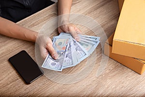 Top view shot of merchandise table with a lot of earning money mockup banknote in hands from e-commerce which selling products