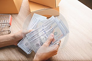 Top view shot of merchandise table with a lot of earning money mockup banknote in hands from e-commerce which selling products