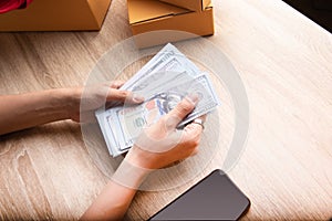 Top view shot of merchandise table with a lot of earning money mockup banknote in hands from e-commerce which selling products