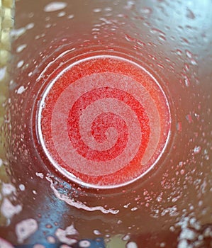 A top view shot of red watermelon juice taken from the edge of the glass