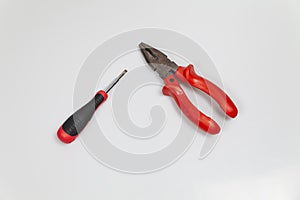 Top view shot of a screwdriver and nippers isolated on white background