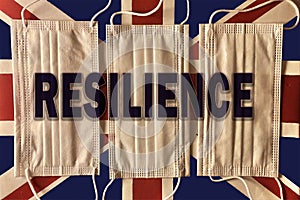 Top view shot of three face masks on the British flag with the word resilience added to the photo