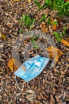 Top view shot of a used medical facemask left on the ground and  disposed of improperly