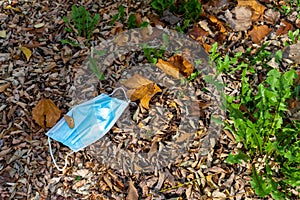 Top view shot of a used medical facemask left on the ground and  disposed of improperly