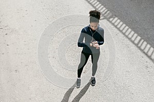 Top view shot of young woman checking activity tracker