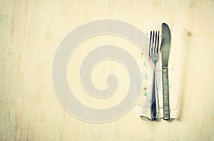 Top view of silver fork and knife over wooden textured background. room for text.