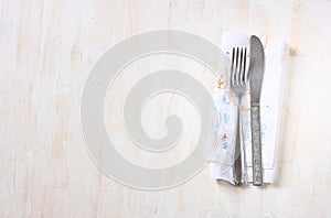 Top view of silver fork and knife over wooden textured background. room for text.