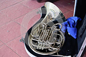 Top view of a silver French horn in a music box for a marching band or jazz band.