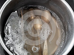 Top view of silver teaspoons in boiling solution