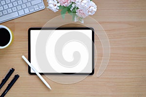 Top view of simple workspace with mock-up tablet, computer device and copy space on wooden table background