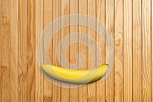Top view of single banana on wooden table background
