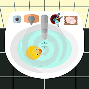 Top view on a sink in a bathroom with the yellow rubber duck