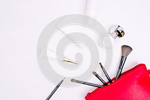 Top view of skin cream and cosmetics with a red bag on a white background with copy space