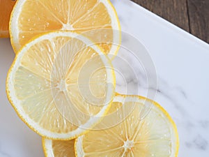 Top view slice lemon fruit on marble cutting board.