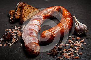 top view on sliced circle of dry-cured ham sausage with rye bread