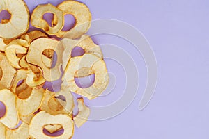 Top view of sliced dry healthy snack apple on violet background. Health lifestyle food. Homemade sweets and dessert. Organic food