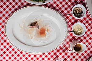 Top view of Sliced medium rare charcoal grilled wagyu Ribeye steak in white plate on red and white pattern tablecloth.