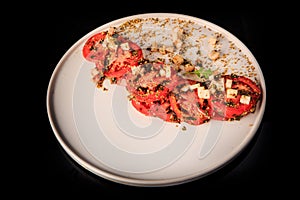 top view on sliced tomato finely decorated with assorted herbs