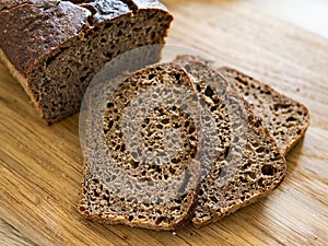 Top view of sliced wholegrain rye bread on wooden background closeup.