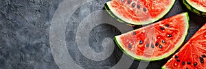 Top view of slices of juicy fresh watermelon served on dark surface, panoramic empty space