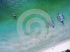 Top view small beach with vacationing people, banca boats and pa