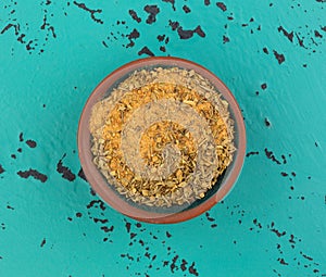 Top view of a small bowl filled with Cajun blackened seasoning on a green and black tabletop