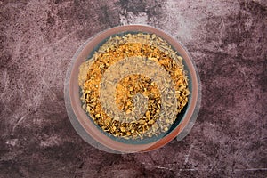 Top view of a small bowl filled with Cajun blackened seasoning on a red mottled tabletop photo