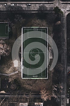 Top view of a small training football field in the city. Soccer pitch with artificial turf in an urban setting during