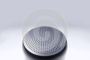 Top view of small wireless speaker showing black metal grille