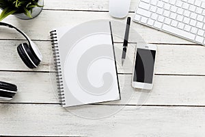 Top view smart phone with computer and empty notebook on wooden table