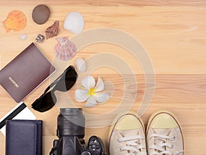 Top view smart phone, passport, Sunglasses, Credit Cards, shoes, camera. with copy space on wooden background.