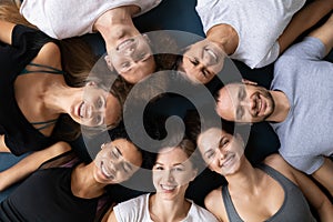 Top view smiling diverse people lying in circle on mats