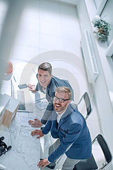 Top view. smiling fellow architects looking at the camera