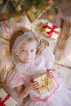 Top view of smiling female kid with golden present