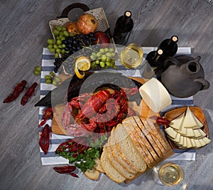 Top view of smoked sturgeon, crustaceans, fruits and wine