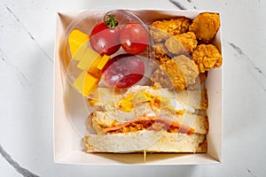 snack of sandwich and deep fried diced chicken and grape and mangoes and sweet potatoes