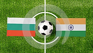 Top view soccer ball with Bulgaria vs. India flags match on green football field