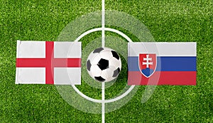 Pohľad zhora na futbalovú loptu s vlajkami Anglicka vs. Slovensko na zelenom futbalovom ihrisku