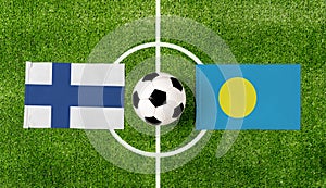 Top view soccer ball with Finland vs. Palau flags match on green football field