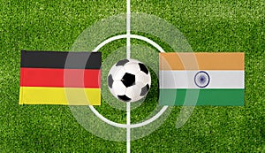 Top view soccer ball with Germany vs. India flags match on green football field