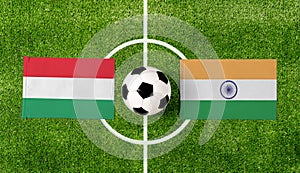 Top view soccer ball with Hungary vs. India flags match on green football field