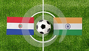 Top view soccer ball with Paraguay vs. India flags match on green football field