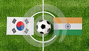 Top view soccer ball with South Korea vs. India flags match on green football field