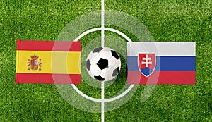 Pohľad zhora na futbalovú loptu so zápasom vlajky Španielska vs. Slovensko na zelenom futbalovom ihrisku